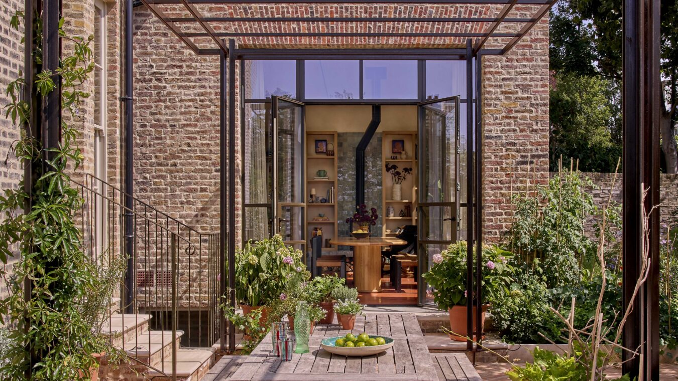 Large glass doors opening the interior dining space up to the paved garden patio