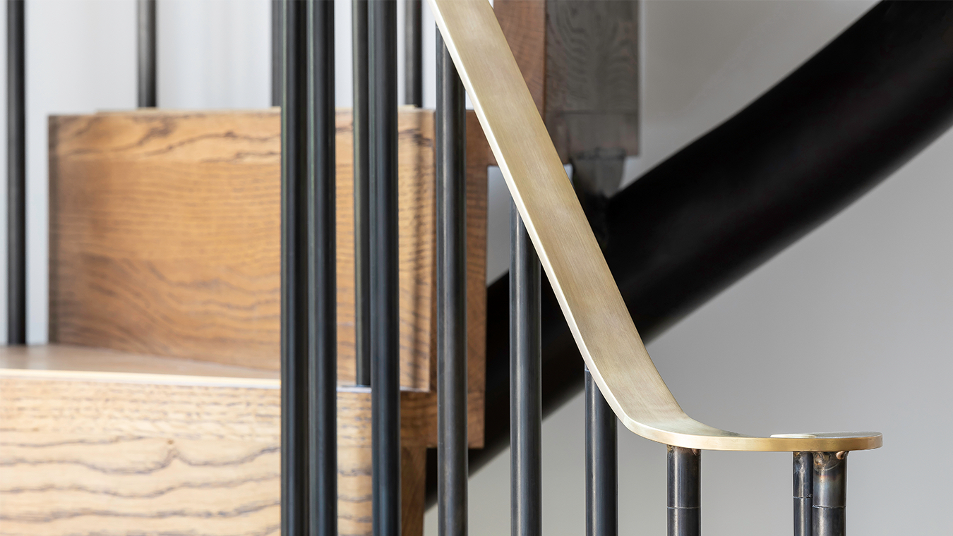 Close-up detail of the brass handrail and metal spindles