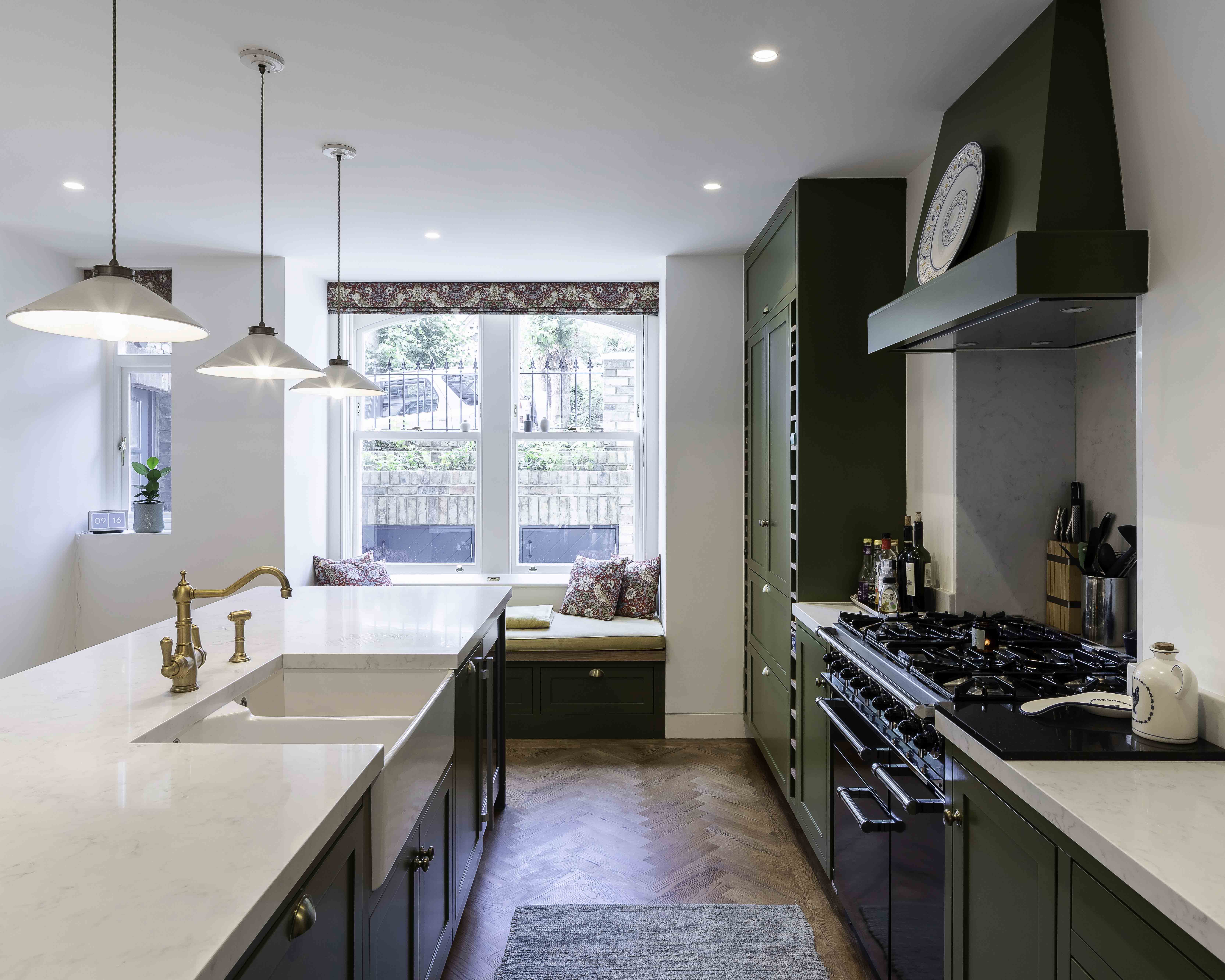 Bright kitchen space featuring olive green cabinetry and a cozy window seat